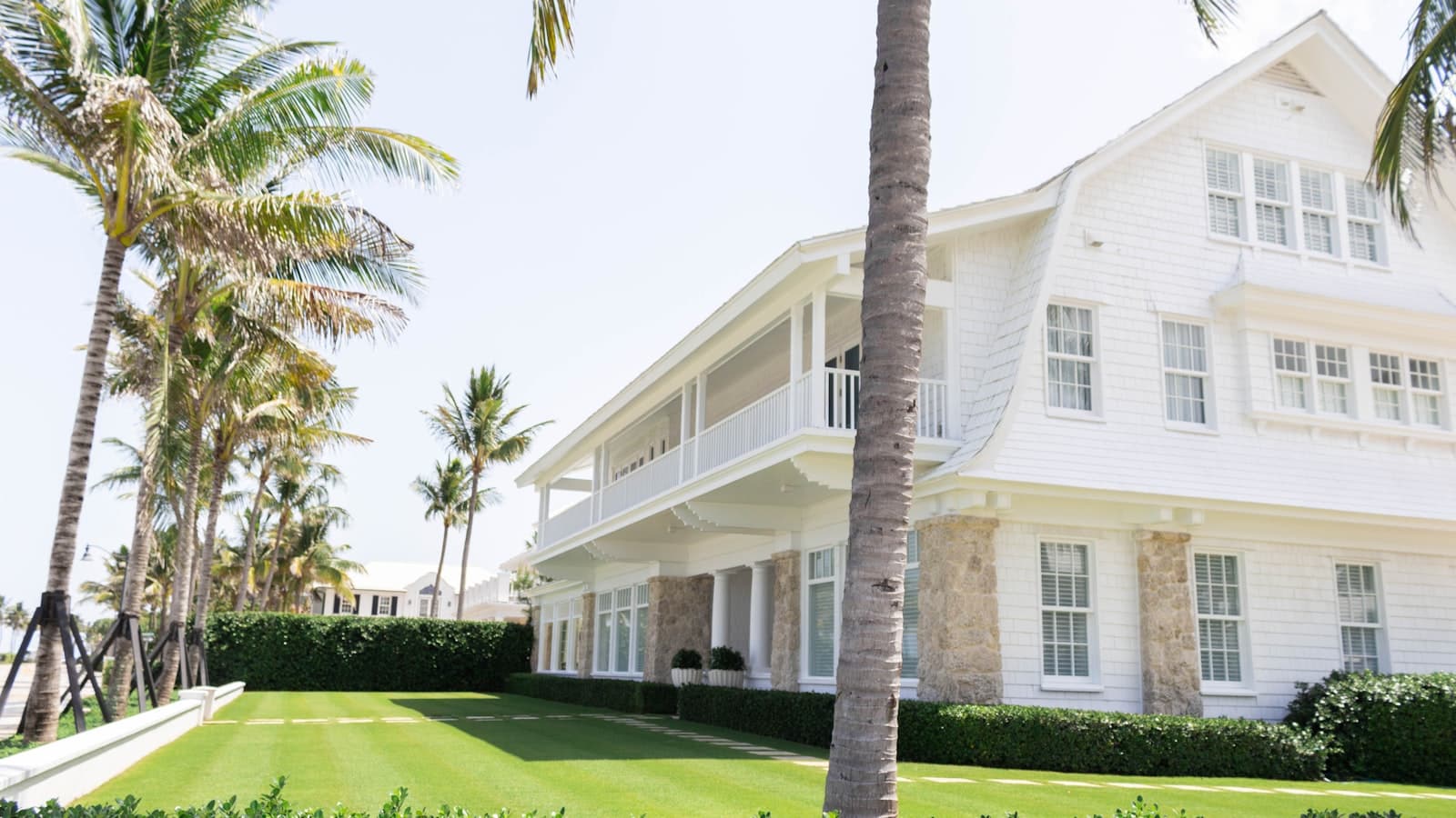 white wooden house near palm trees