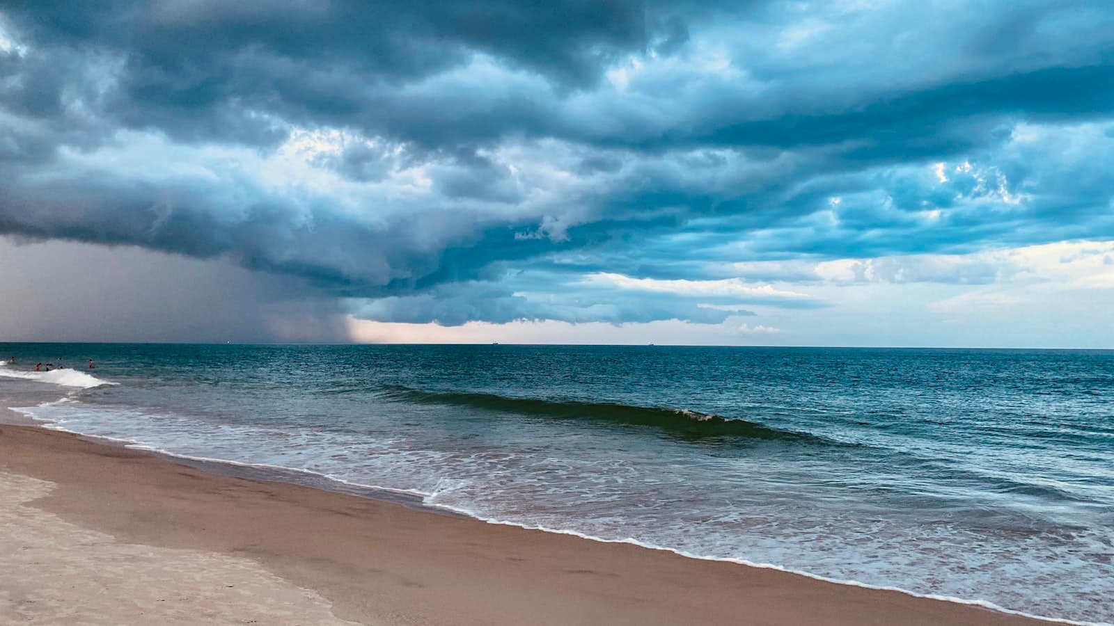 a beach with waves and clouds