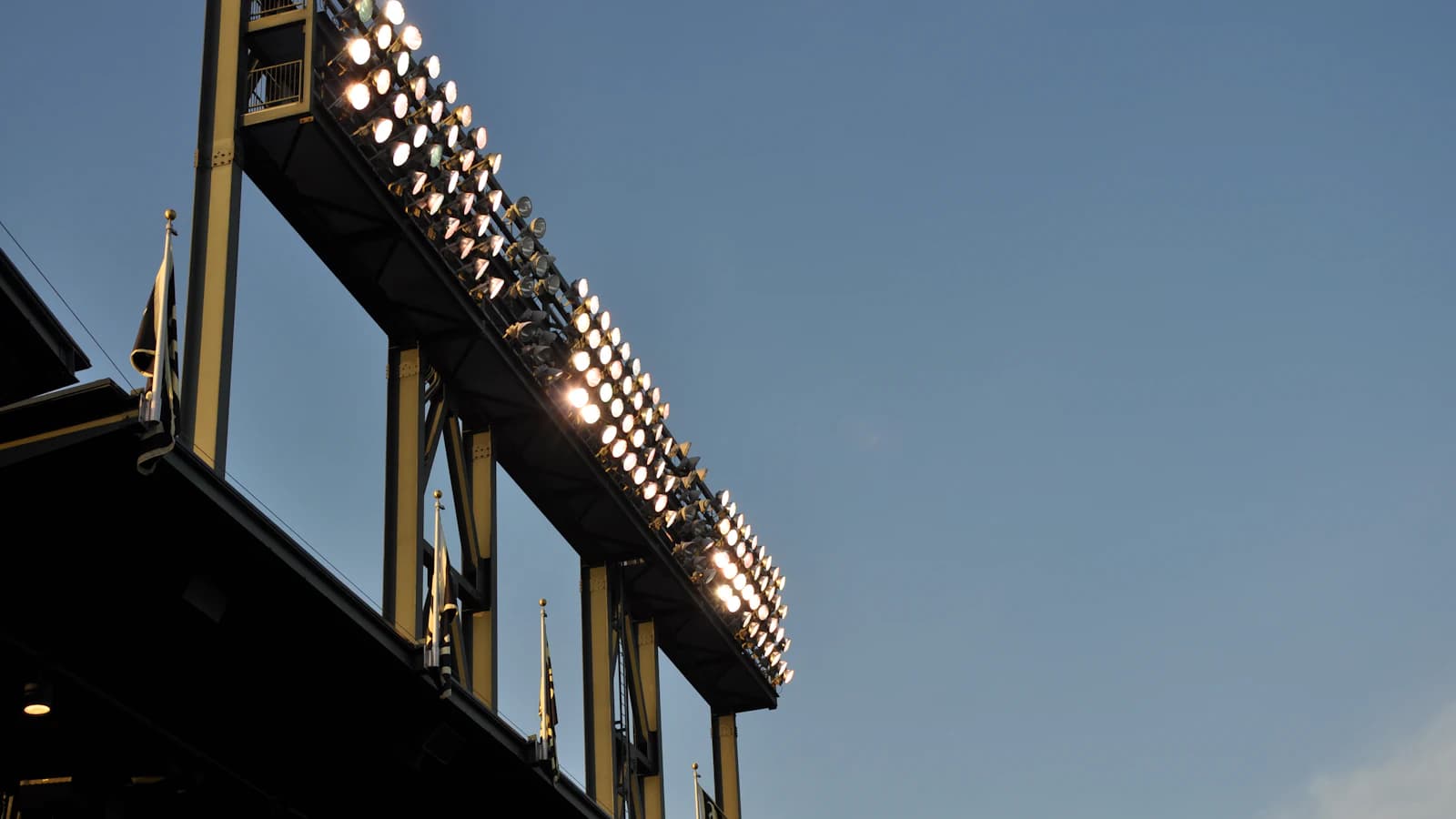 a baseball stadium with lights on and a sky background